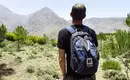 Wanderer mit Rucksack blickt auf Berge im Hohen Atlas, Marokko.