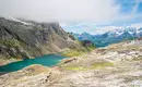 Landschaft in den Schweizer Alpen mit See und Bergen im Hintergrund.