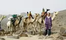 Tuareg mit beladenen Kamelen beim Trekking durch die Sahara.