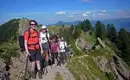 Gruppe von Wanderern auf einem Gebirgspfad im Naturpark Nagelfluhkette mit Alpenpanorama.