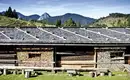 Almhütte vor Bergkulisse in den Alpen bei Sonnenschein