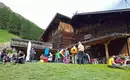 Wanderer genießen eine Pause vor einer traditionellen Alpenhütte in den Bergen.