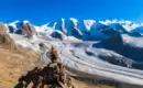 Ein beeindruckender Blick auf die schneebedeckten Gipfel und Gletscher der Alpen im Oberengadin bei klarem blauem Himmel.