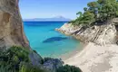 Idyllische Bucht mit türkisblauem Meer, umgeben von Felsen und Pinien in Chalkidiki.