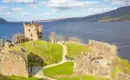 Blick auf Loch Ness mit ruhigem Wasser und weitläufiger Landschaft in Schottland.