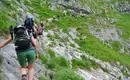 Gruppe von Wanderern auf steinigem Bergpfad im Berchtesgadener Land.