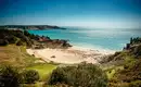 Blick auf die sandigen Buchten und grüne Küsten von Jersey unter blauem Himmel.