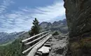 Schmaler Bergpfad mit Geländer vor majestätischen Bergen im Ortler Gebiet.