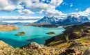 Panoramablick über den Torres del Paine Nationalpark mit Bergen und Seen unter einem wolkigen Himmel.