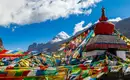 Mount Kailash in Tibet hinter bunten Gebetsfahnen und einer Stupa.