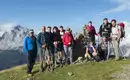 Eine Gruppe von Wanderern auf einem Berggipfel in Südtirol mit Ausblick auf die Alpen.