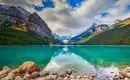 Ein smaragdgrüner See umgeben von schneebedeckten Bergen in den Rockies.