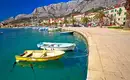 Boote am Kai mit Blick auf das Biokovo-Gebirge bei der Makarska-Riviera.