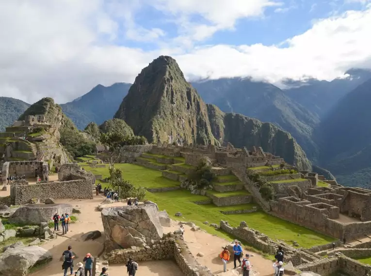 Blick auf die antiken Ruinen von Machu Picchu, umgeben von grünen Bergen.