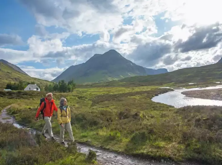 Zwei Wanderer genießen die Landschaft der schottischen Highlands.