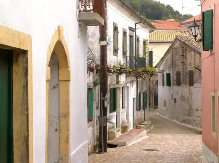 Malerrische Gasse mit traditionellen Häusern in einem Dorf auf Korfu.