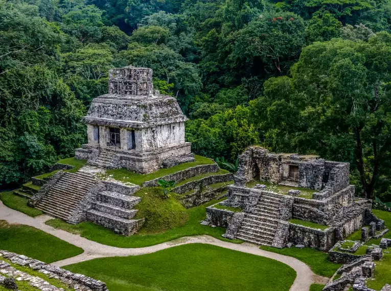 Alte Maya-Tempel umgeben von dichtem Regenwald.