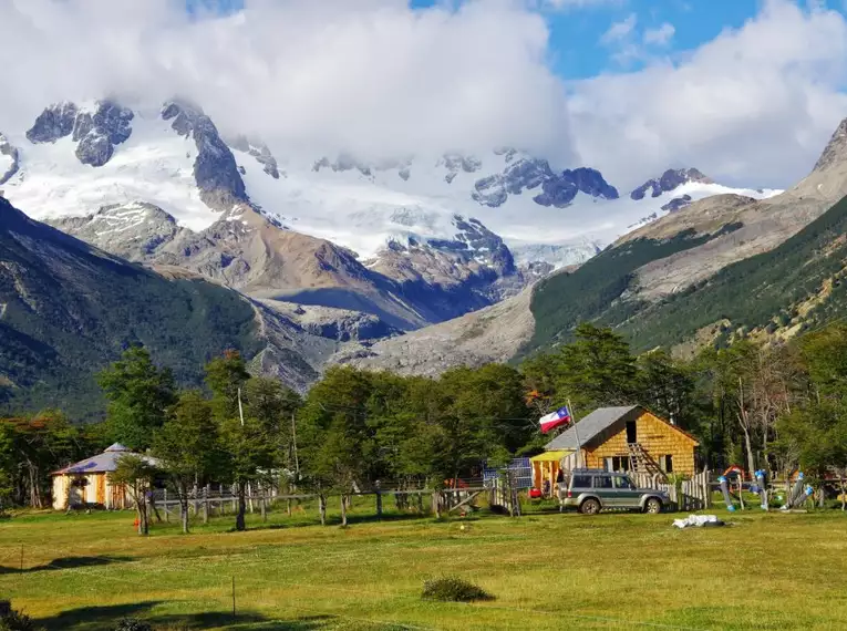 Eine gemütliche Estancia in einer grünen Berglandschaft Patagoniens.