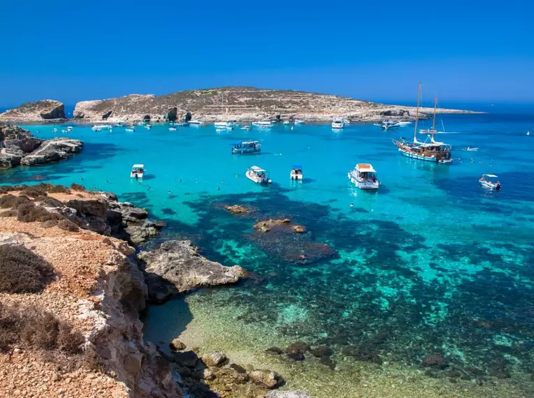 Tiefblaues Meer und Boote in der blauen Lagune, Comino, Malta.