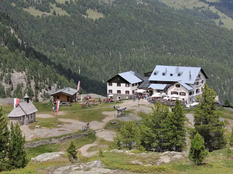 Zufallhütte und angrenzende Gebäude in alpiner Landschaft des Martelltals.