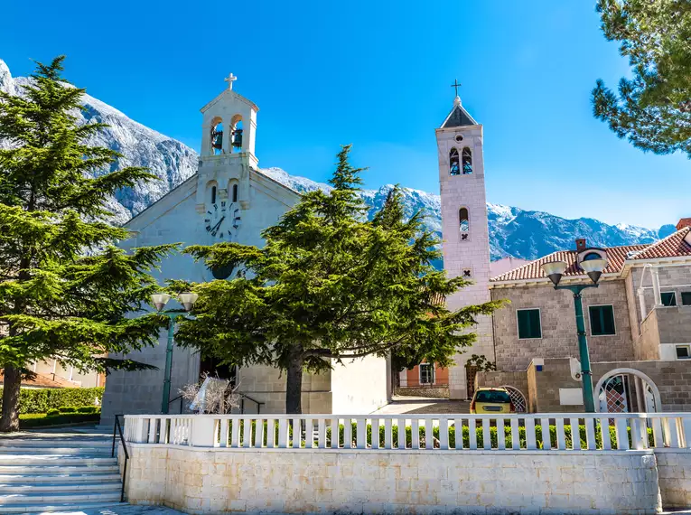 Eine malerische Kirche mit Bergen im Hintergrund in Dalmatien, Kroatien.