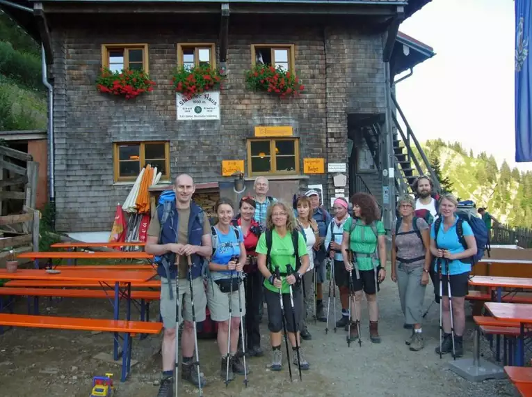 Eine Gruppe Wanderer posiert vor einer Berghütte in der Nagelfluhkette.