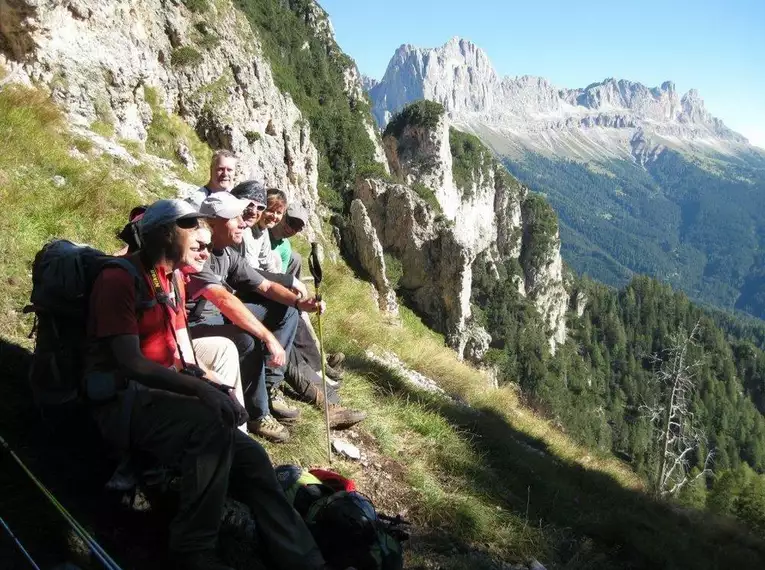 Wanderer machen Rast mit Blick auf die Alpenlandschaft