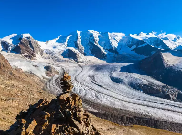 Ein beeindruckender Blick auf die schneebedeckten Gipfel und Gletscher der Alpen im Oberengadin bei klarem blauem Himmel.