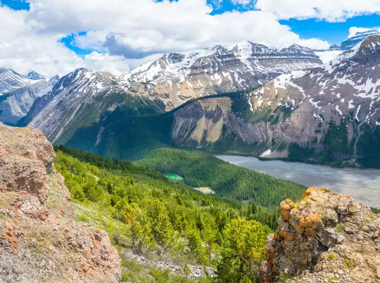 Blick auf verschneite Berge und bewaldete Täler in Kanada.