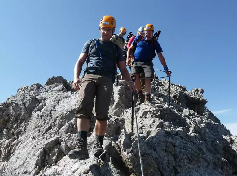 Bergwanderer auf dem Heilbronner Höhenweg mit Kletterausrüstung bei klarem Wetter.