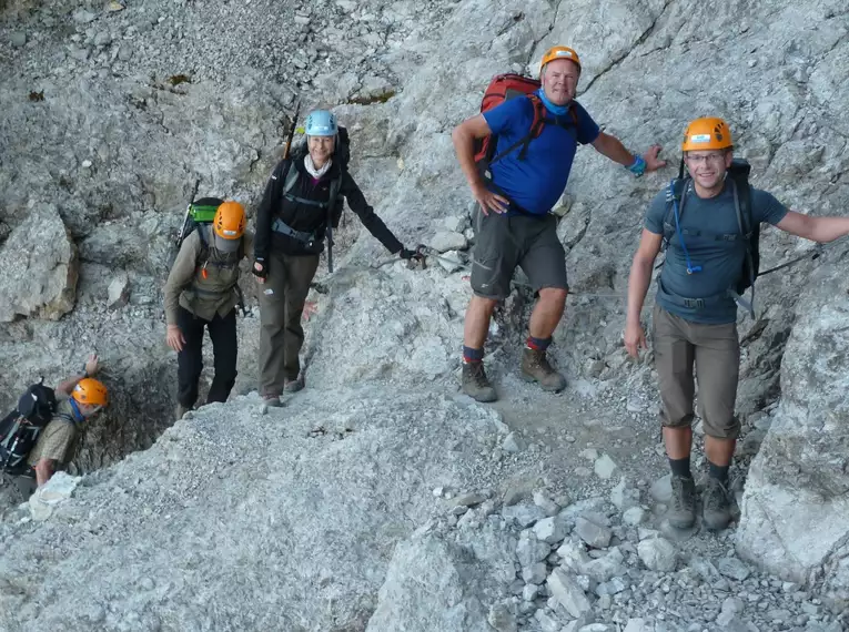 Gruppe von Wanderern mit Helmen auf dem steinigen Teil des Heilbronner Höhenwegs in den Allgäuer Alpen.