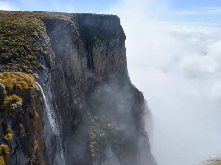 Steile Felswand in den Drakensbergen von Wolken umgeben