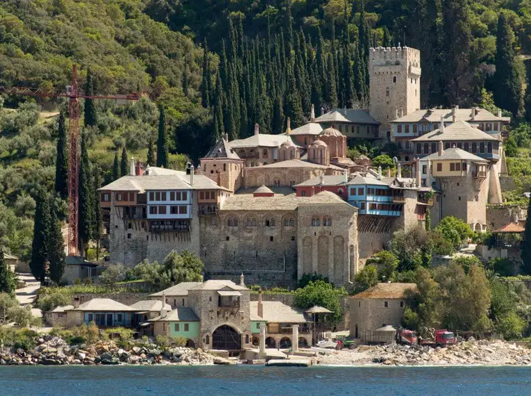 Historisches Kloster an der Küste von Chalkidiki umgeben von Bäumen und Meer