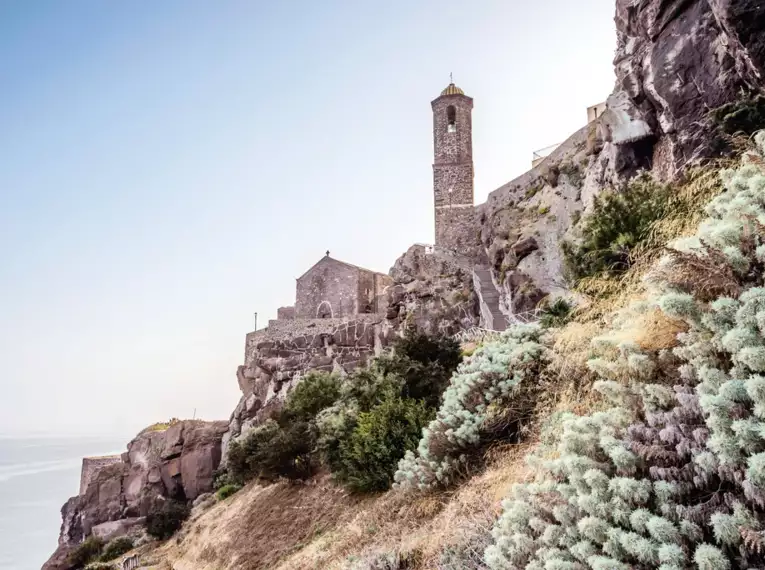 Eine alte Steinkirche auf einem Felsvorsprung an der Küste Sardiniens.