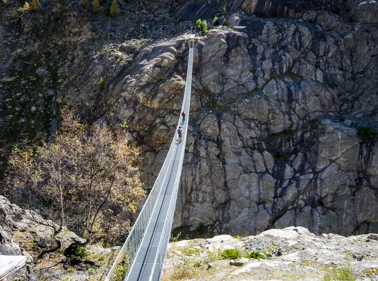 Personen überqueren eine Hängebrücke in den Schweizer Alpen.