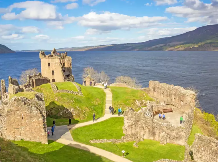 Blick auf Loch Ness mit ruhigem Wasser und weitläufiger Landschaft in Schottland.