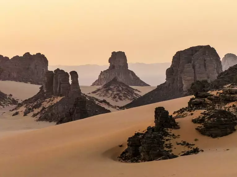 Faszinierende Felsformationen und Sanddünen in der Sahara bei Sonnenuntergang.