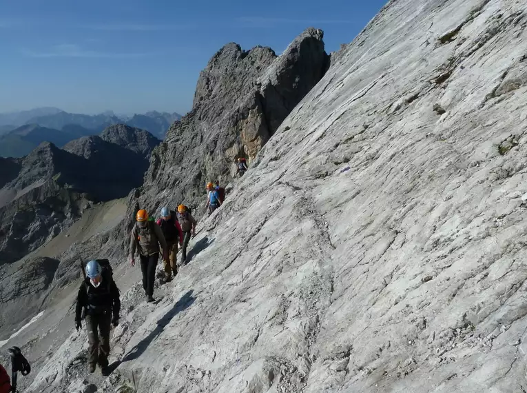 Gruppe von Wanderern auf steilem Gebirgspfad im Allgäu