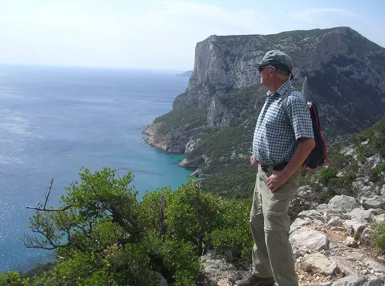 Person genießt Ausblick auf Sardiniens Küste während einer Wanderung.