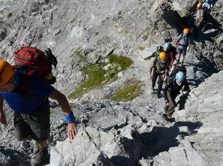 Gruppe von Wanderern auf dem Heilbronner Höhenweg in alpiner Landschaft mit Kletterpassagen.