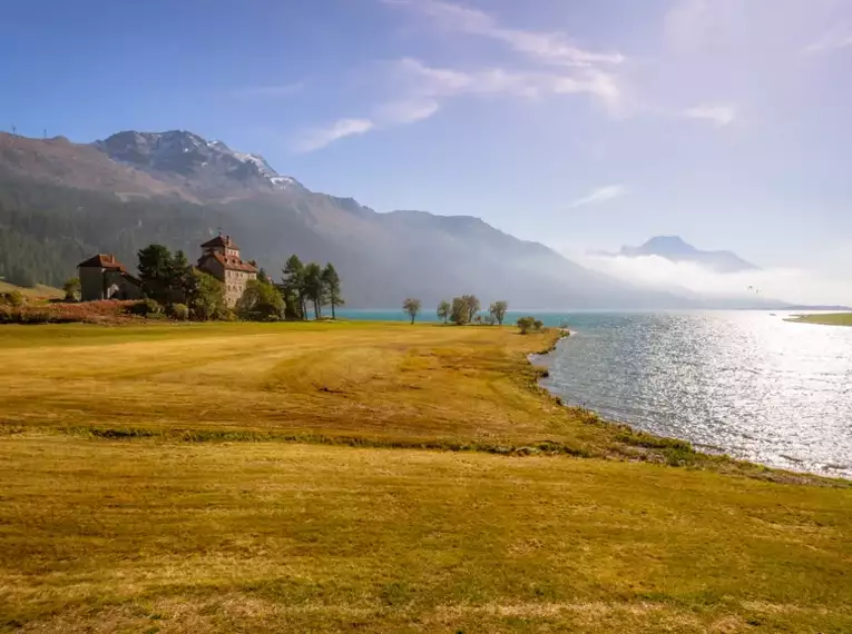 Maleblick auf einen See mit Bergkulisse im Oberengadin.