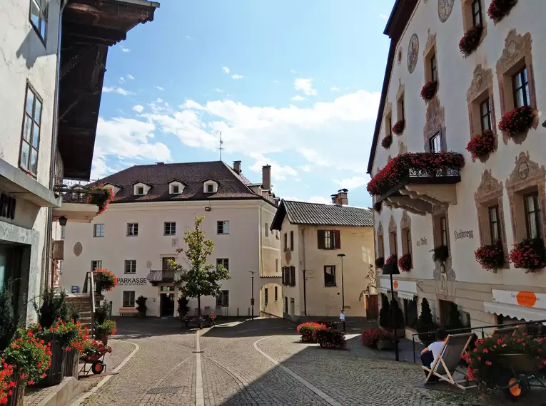 Ein malerisches Dorf mit blumengeschmückten Häusern und gepflasterten Straßen.