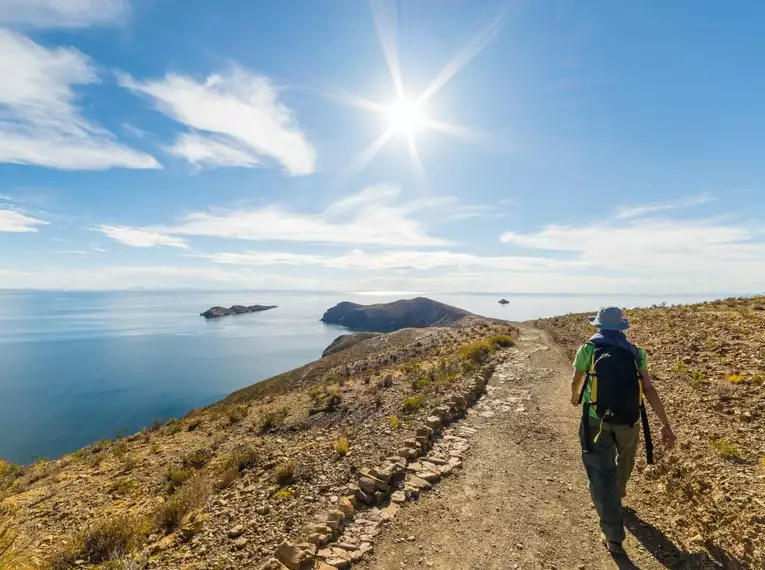 Person wandert auf der Isla del Sol mit Blick auf den Titicaca-See.