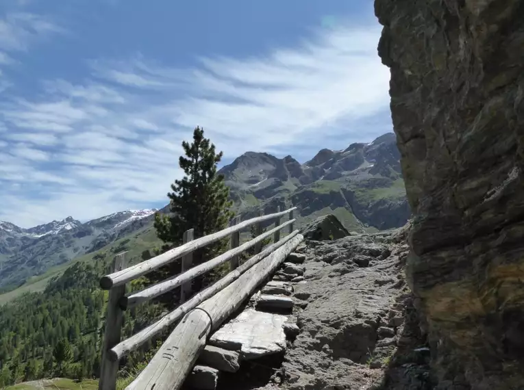 Schmaler Bergpfad mit Geländer vor majestätischen Bergen im Ortler Gebiet.