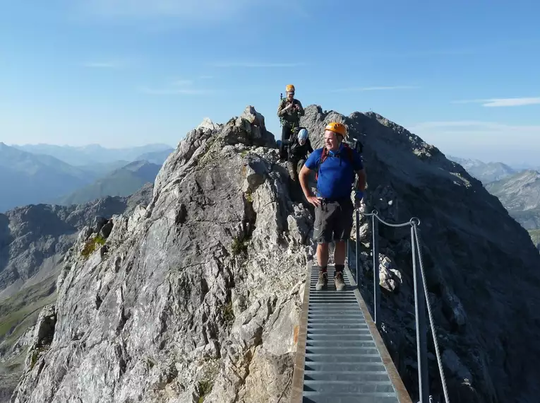 Bergsteiger mit Helm auf schmalem Steg im Allgäuer Hochgebirge