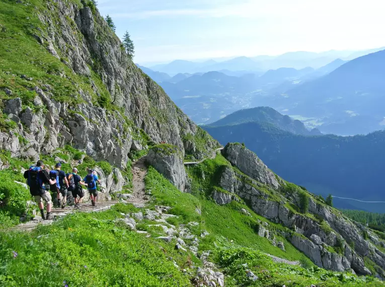 Wanderer auf einem steinigen Bergpfad mit atemberaubender Aussicht.