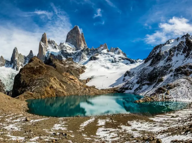 Schneebedeckte Berge und türkisfarbene Lagune in Patagonien.