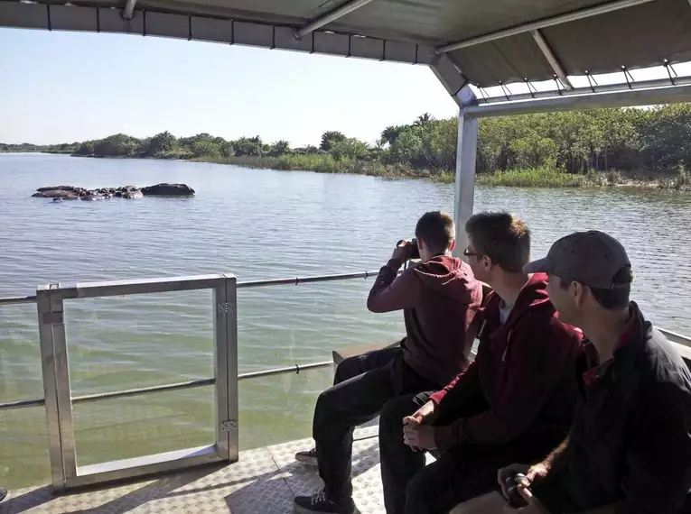 Touristen beobachten Flusspferde während einer Bootssafari im Isimangaliso Naturpark in Südafrika.