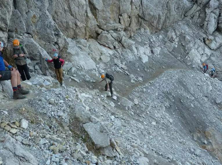 Gruppe von Wanderern auf einem steinigen Pfad im Gebirge