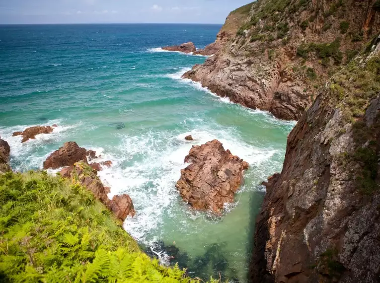 Beeindruckende Klippen und grünes Meer an Jerseys Küste.